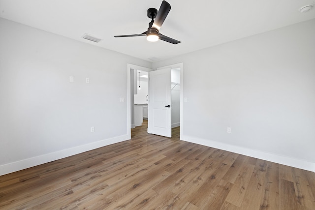 unfurnished bedroom featuring visible vents, wood finished floors, a ceiling fan, and baseboards