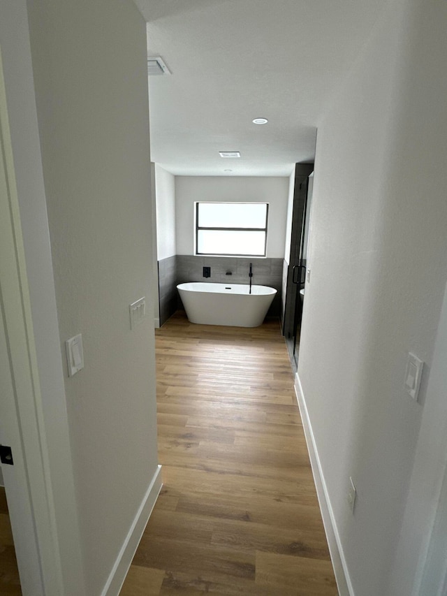 corridor with light hardwood / wood-style floors