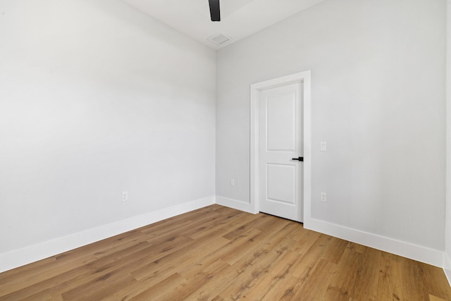 empty room with a ceiling fan, light wood-type flooring, visible vents, and baseboards