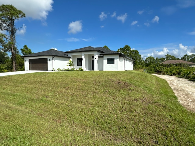 prairie-style house featuring a front lawn and a garage