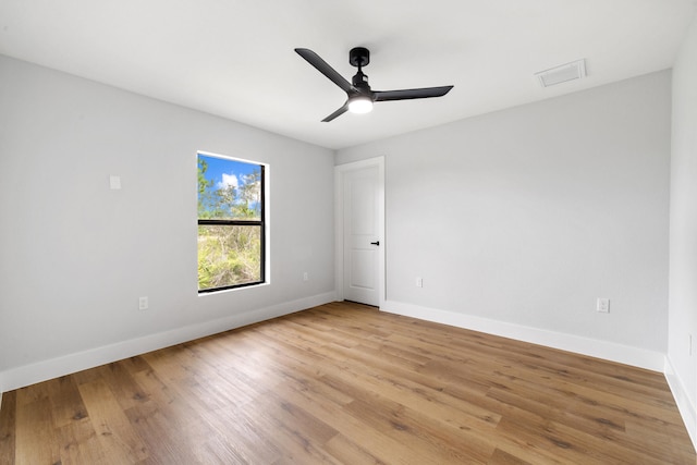 spare room with visible vents, light wood finished floors, a ceiling fan, and baseboards