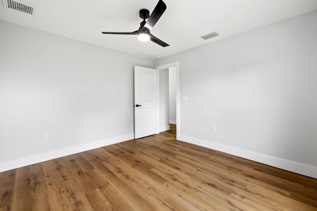 empty room with light wood-style floors, baseboards, visible vents, and a ceiling fan