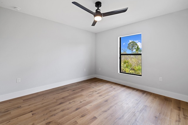 spare room featuring light wood-style floors, ceiling fan, and baseboards