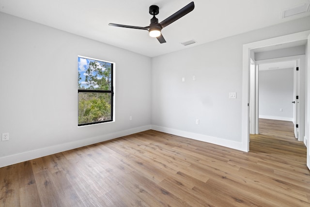 empty room featuring light wood-type flooring, visible vents, ceiling fan, and baseboards