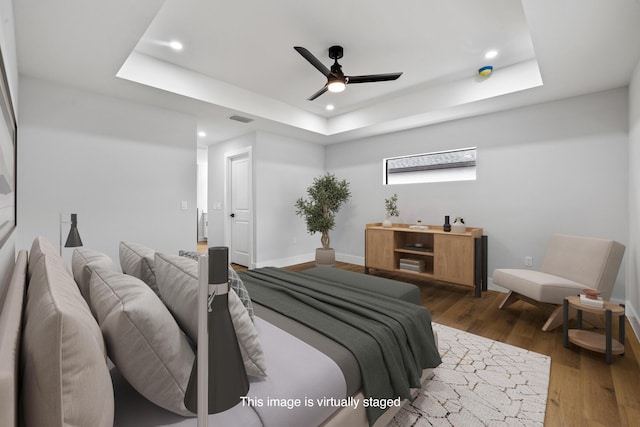 bedroom with recessed lighting, a raised ceiling, visible vents, and dark wood finished floors