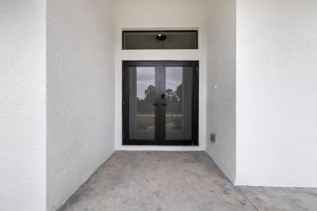 entrance to property featuring french doors and stucco siding