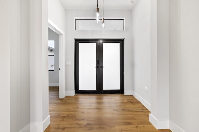 entryway featuring french doors, baseboards, and wood finished floors