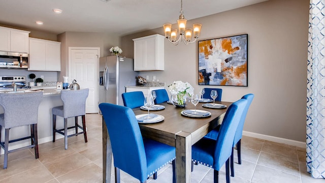 dining space featuring light tile patterned floors and an inviting chandelier