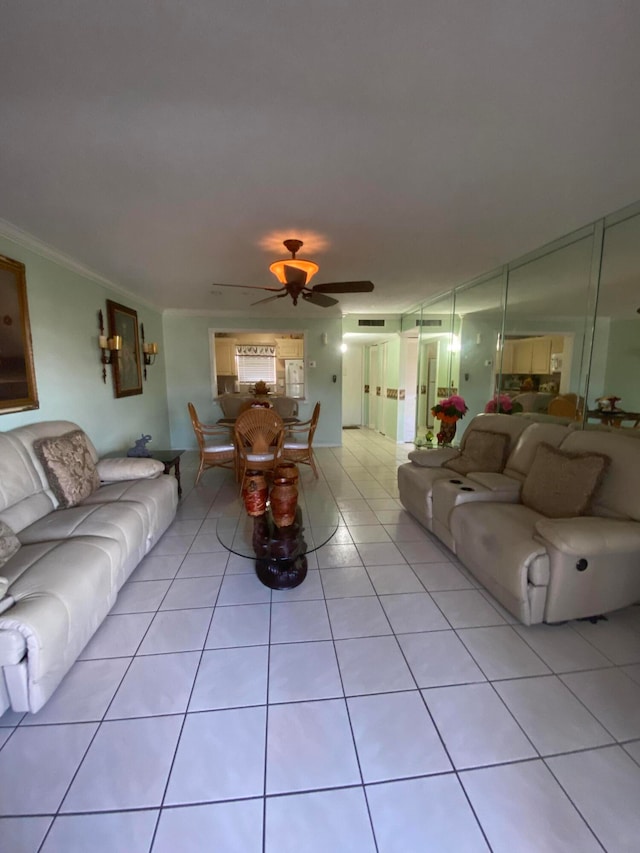 living room featuring ceiling fan, ornamental molding, and light tile patterned flooring