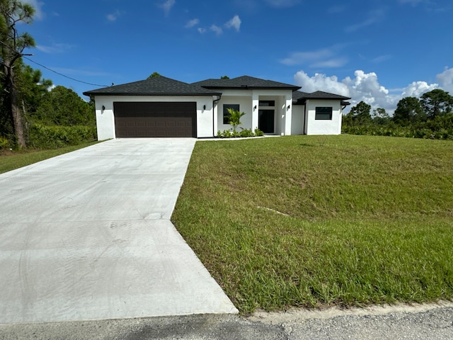 prairie-style home with a front yard and a garage