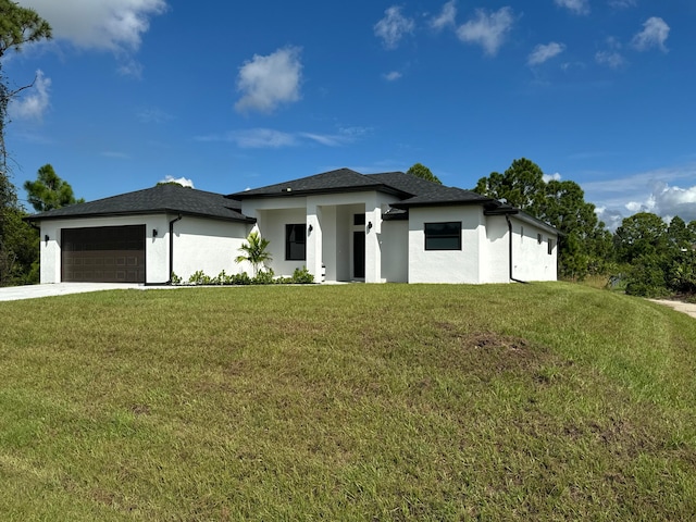 prairie-style house with a garage and a front lawn