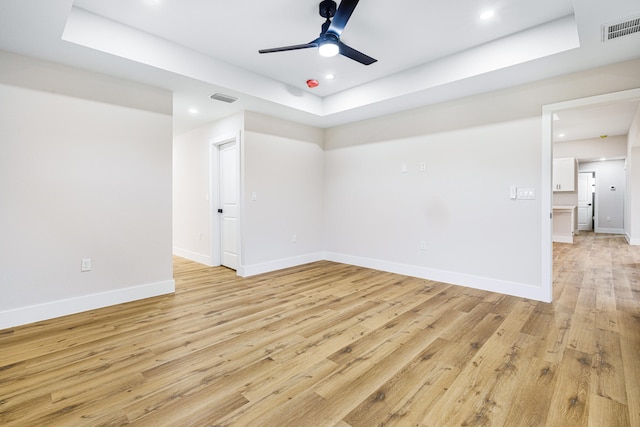 empty room featuring baseboards, visible vents, and light wood finished floors