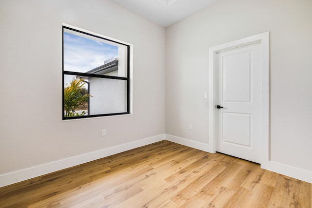 unfurnished room with baseboards and light wood finished floors