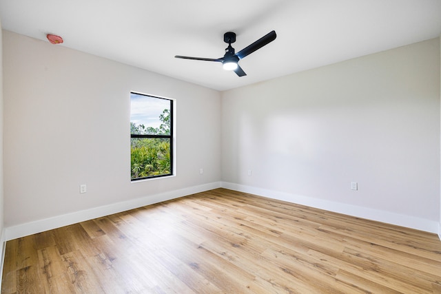 empty room featuring light wood-type flooring, baseboards, and a ceiling fan