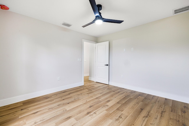 unfurnished room with light wood-type flooring, baseboards, visible vents, and a ceiling fan