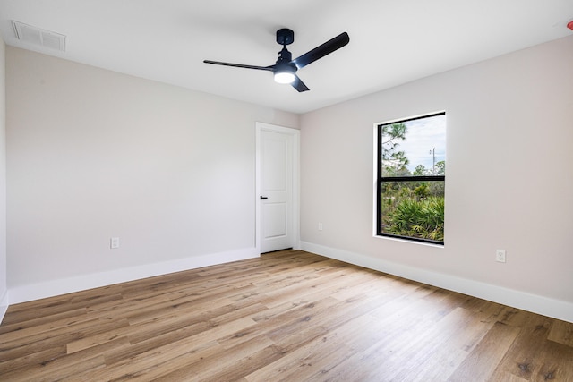 spare room with light wood-style floors, baseboards, visible vents, and a ceiling fan