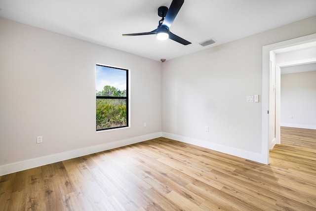 spare room with light wood-style floors, baseboards, visible vents, and ceiling fan