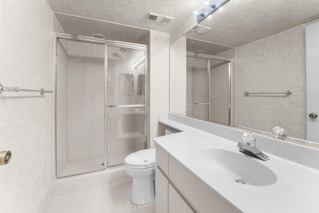 bathroom featuring vanity, toilet, a shower with shower door, and a textured ceiling