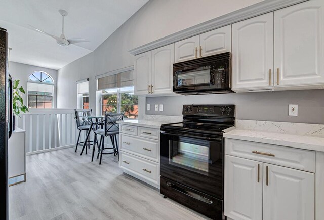 kitchen featuring light stone counters, vaulted ceiling, sink, and a chandelier