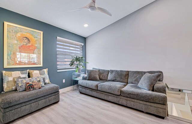 living room featuring lofted ceiling, ceiling fan, and light hardwood / wood-style floors