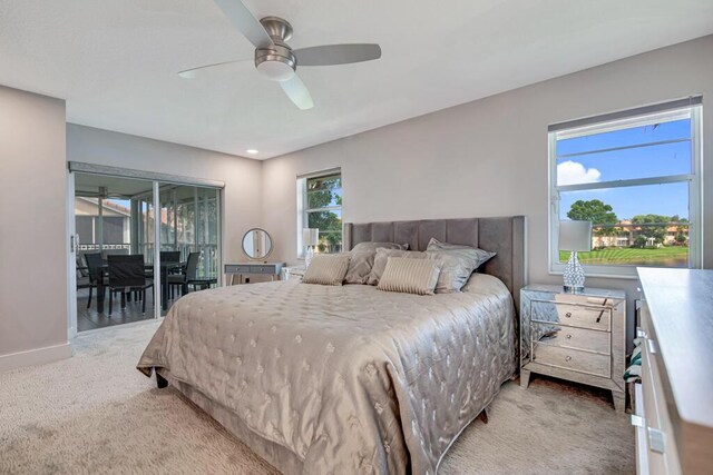 carpeted bedroom featuring multiple windows and ceiling fan