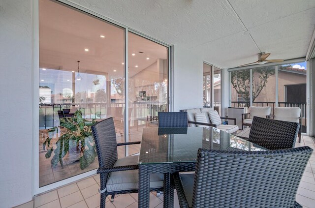 sunroom / solarium with ceiling fan and a water view