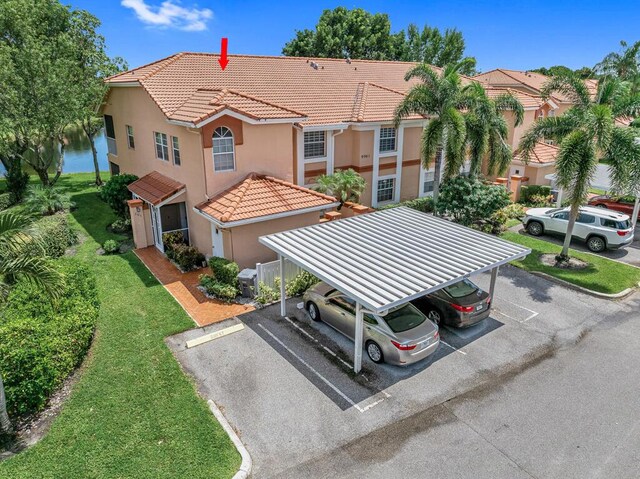 mediterranean / spanish-style home with a front yard and a carport