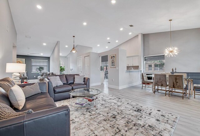 living room with vaulted ceiling and light wood-type flooring