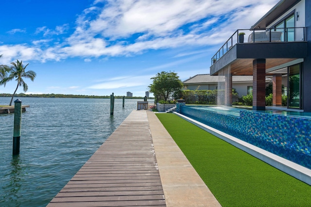 dock area with a balcony and a water view