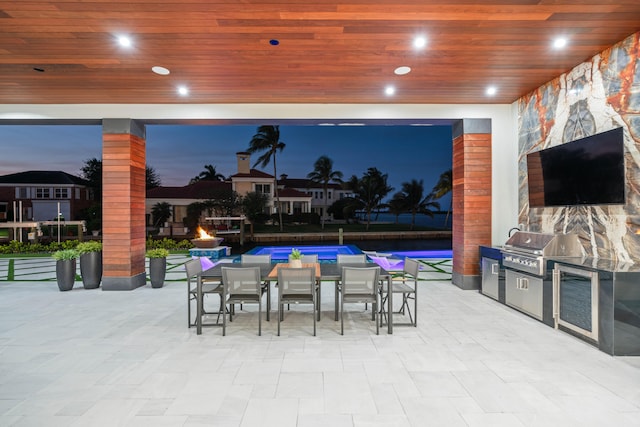 view of patio featuring a grill, an outdoor kitchen, and a pool