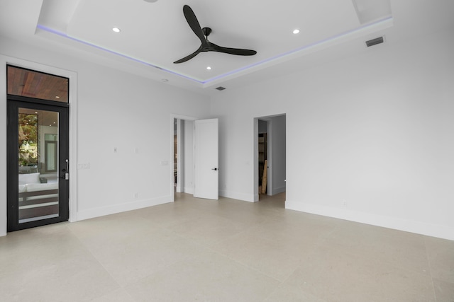 unfurnished room featuring ceiling fan and a tray ceiling