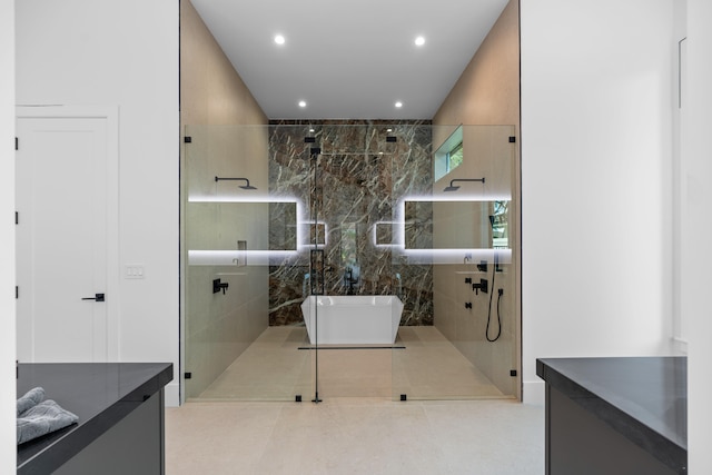 bathroom featuring vanity, tile walls, and shower with separate bathtub