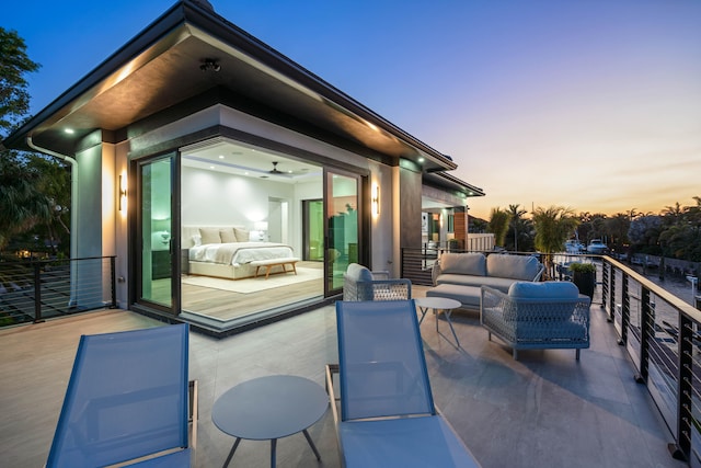 patio terrace at dusk with an outdoor living space and a balcony