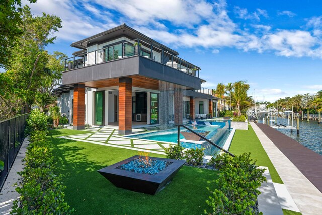 back of property featuring a patio area, a balcony, a fenced in pool, a yard, and a water view