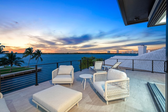 patio terrace at dusk with a water view and a balcony