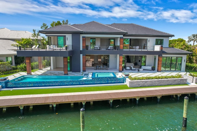 rear view of house featuring a balcony, a water view, and a patio