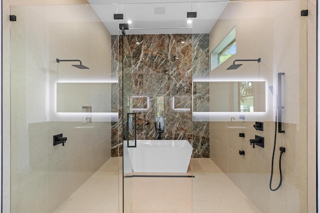 bathroom featuring shower with separate bathtub and tile walls