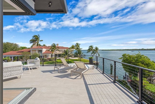 view of patio featuring a balcony and a water view