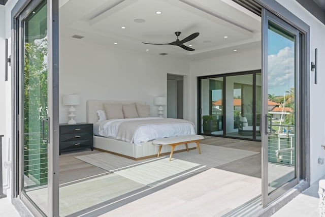 unfurnished bedroom featuring light wood-type flooring, multiple windows, access to outside, and ceiling fan