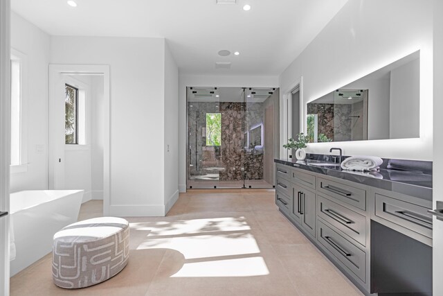 bathroom featuring vanity, plus walk in shower, and tile patterned flooring