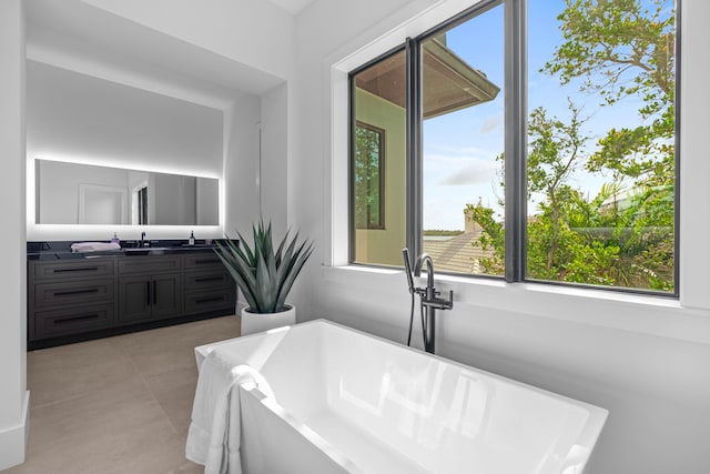 bathroom with tile patterned floors, a bathtub, and vanity