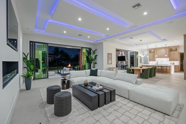 living room featuring a raised ceiling and sink