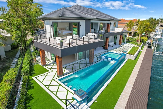 view of swimming pool featuring a lawn, a patio area, and an in ground hot tub