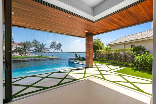 view of pool featuring a patio area, pool water feature, and a water view