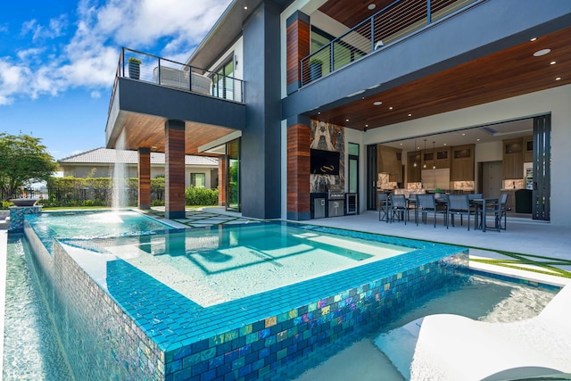 view of swimming pool featuring an in ground hot tub, pool water feature, and a patio