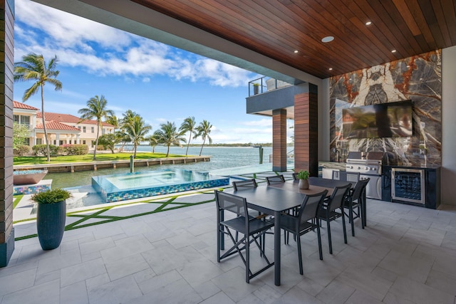 view of patio / terrace with a balcony, a water view, a pool with hot tub, area for grilling, and grilling area