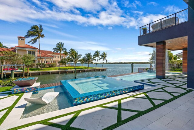 view of swimming pool with a water view, pool water feature, a patio area, and an in ground hot tub