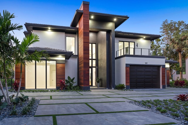 contemporary house featuring a garage and a balcony