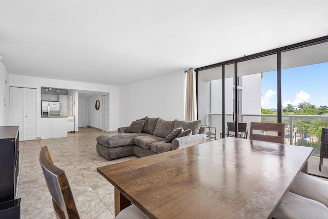 dining area with a wall of windows and light tile patterned floors