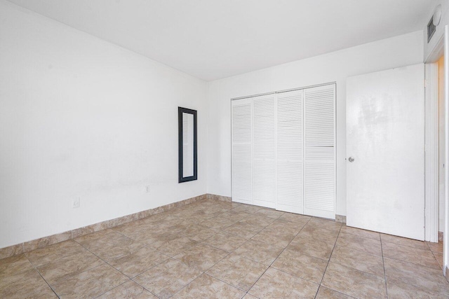 unfurnished bedroom featuring a closet and light tile patterned flooring